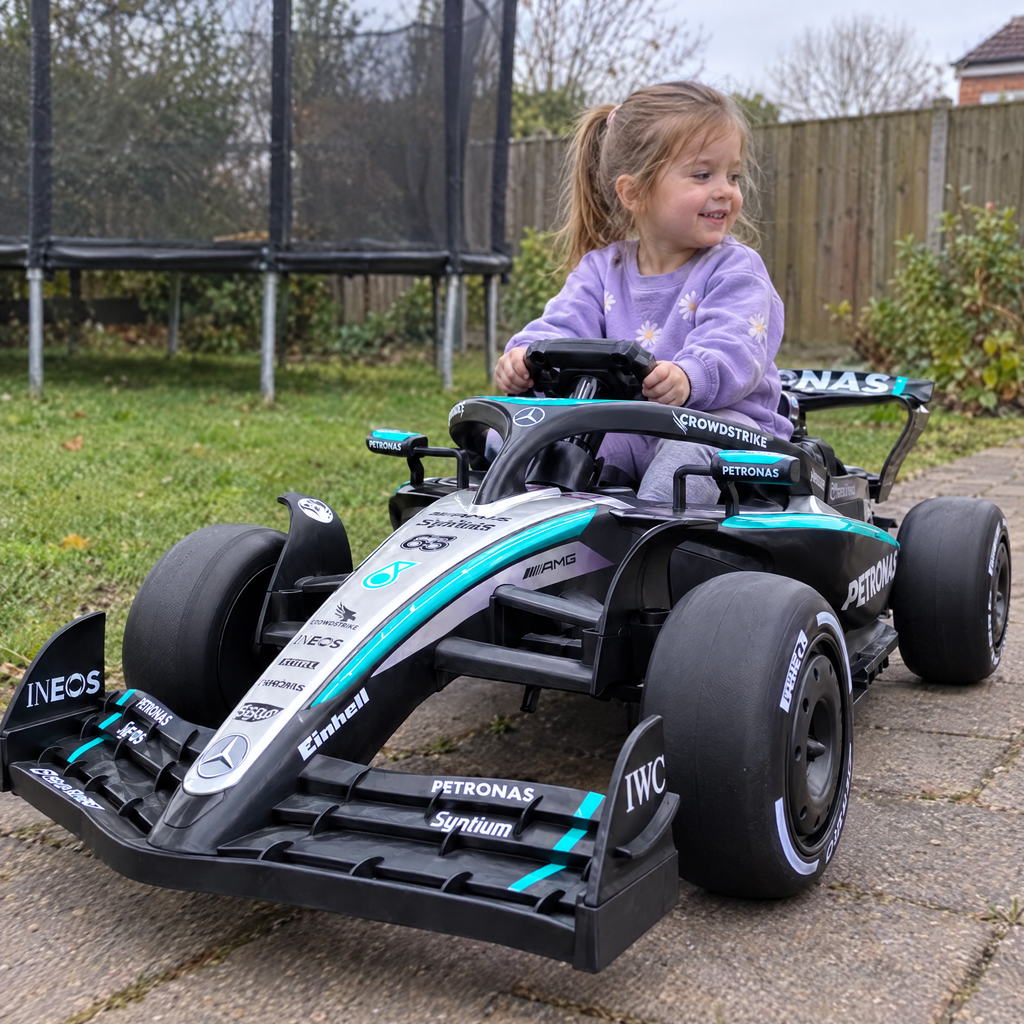Petite fille au volant de la F1 Mercedes-AMG électrique dans le jardin