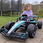 Petite fille au volant de la F1 Mercedes-AMG électrique dans le jardin
